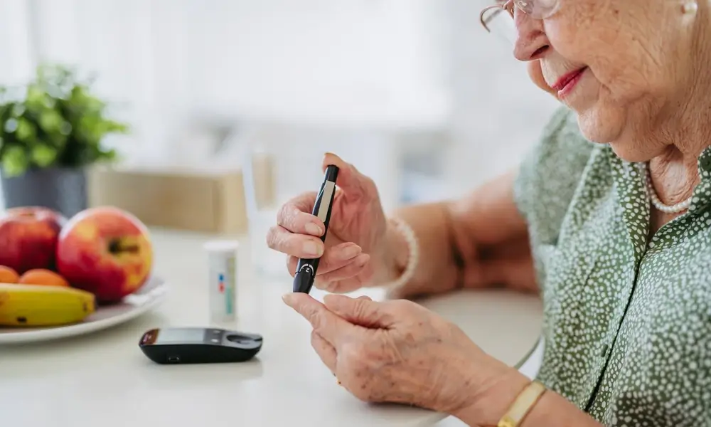 Senior woman checking blood sugar at home