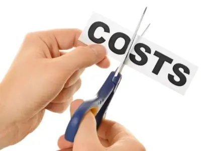 Hands cutting word COSTS with scissors