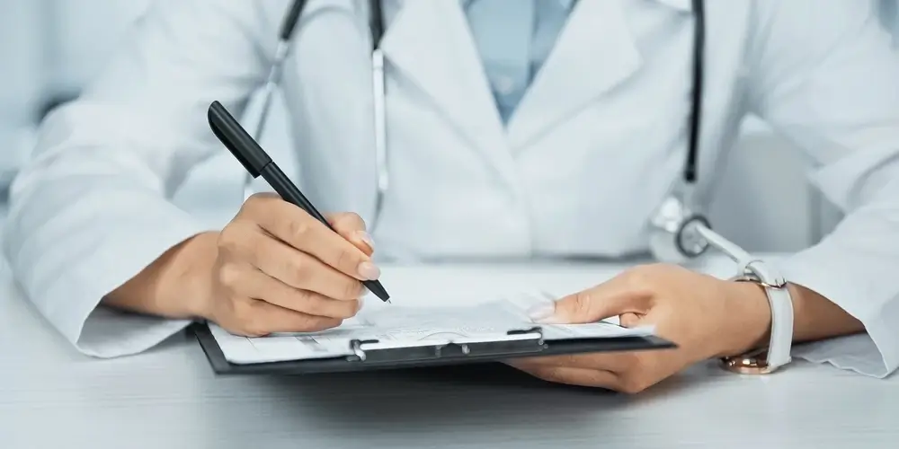 Doctor writing on clipboard in medical office