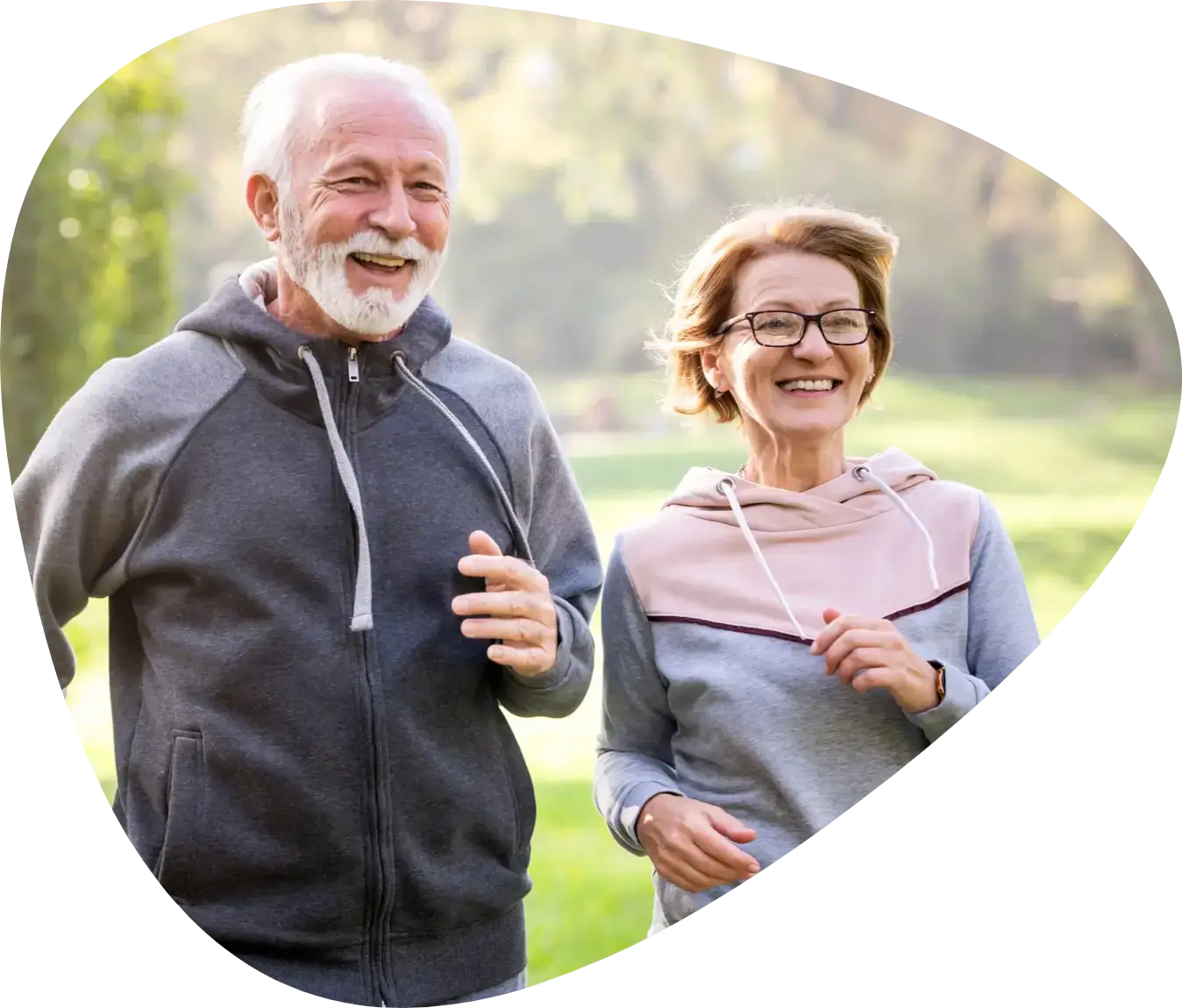 Elderly couple joyfully jogging in park